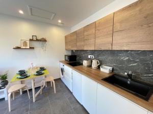 a kitchen with white cabinets and a table with chairs at Petite maison Disneyland Paris in Magny-le-Hongre +6 photos