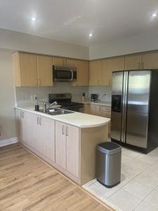 a kitchen with a stainless steel refrigerator and wooden cabinets at Beautiful home in Mississauga
