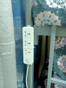 a white socket on a bed next to a bunk bed at The Sky Hosteller Dubai in Dubai