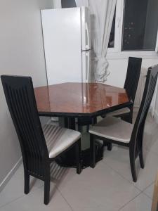 einen Esstisch mit 2 Stühlen und einen Kühlschrank in der Unterkunft Peaceful home in Sevran