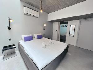 a bedroom with a large white bed with blue pillows at STUNNING AND SPACIOUS - 1BR PENTHOUSE in Valletta