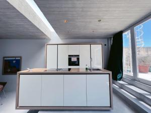 a kitchen with white cabinets and a large window at STUNNING AND SPACIOUS - 1BR PENTHOUSE in Valletta