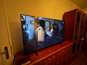 a large flat screen tv sitting on a wooden entertainment center at MONFas APARTMENT GARDEN CITY in Prague