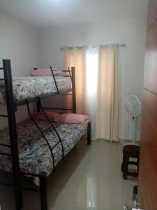 グアダラハラにあるCasa en coto a 5 min de Tonalá centro y centralのベッドルーム1室(二段ベッド2台、ファン付)