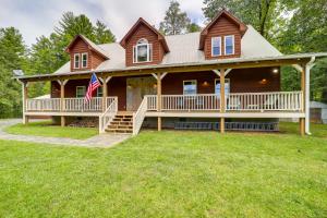 Casa de madera grande con porche y bandera americana en North Carolina Retreat with Deck, Fire Pit and Grill! en Spruce Pine