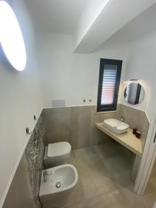 uma casa de banho com um WC, um lavatório e um espelho. em Casa vacanza Scala dei Turchi em Realmonte