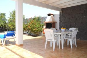 patio ze stołem i krzesłami oraz piecem do pizzy w obiekcie Sun Grove Villas & Spa w mieście Playa Blanca