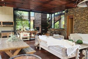 sala de estar con muebles de madera y pared de ladrillo en Maremansa Lake House Guatapé, en Chiquinquirá