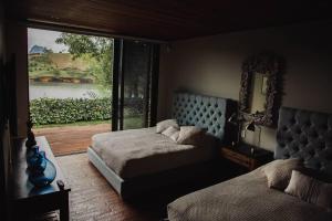 1 dormitorio con 2 camas y vistas al río en Maremansa Lake House Guatapé, en Chiquinquirá 68 fotos más