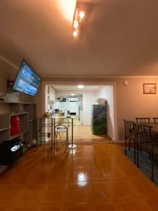 a living room with a table and a tv and a kitchen at Habitación para 4, acogedor, familiar, equipado, baño compartido 
