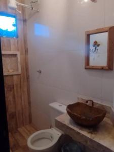 a bathroom with a wooden sink and a toilet at Espaço para Festa e Pousada Alex Ávila in Diamantina