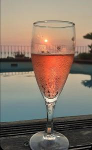una copa de vino sentada en una mesa en Michelangelo-Sunset-Villa, en Santa Marinella