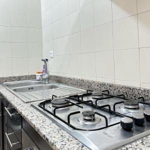 a kitchen counter with a stove and a sink at Best Apartment in Marina Agadir in Agadir