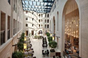 una hall vuota con tavoli e sedie in un edificio di Waldorf Astoria Jerusalem a Gerusalemme