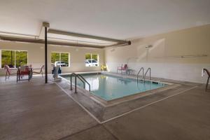 a swimming pool in a room with tables and chairs at Best Western Roosevelt Place in Bismarck
