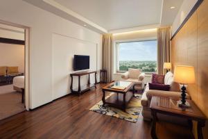 a living room with a couch and a tv at Radisson Blu Hotel Ranchi in Rānchī