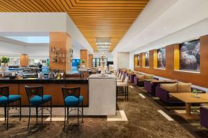 un ristorante con bar, tavoli e sedie di Radisson Blu Hotel Ranchi a Rānchī