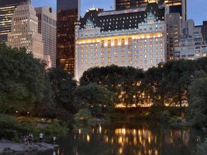 - une vue sur un étang dans une ville avec de grands bâtiments dans l'établissement The Plaza, à New York