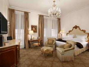 um quarto de hotel com uma cama grande e um lustre em The Plaza em Nova York