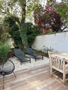 2 sillas, una mesa y un banco en un patio en 3 Bedroom Art-Nouveau Apartment with Free Parking en Ghent