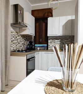 una cocina con armarios blancos y una mesa con palillos de madera. en Pietrapantone B&B, en Pietrapertosa