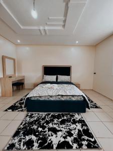 Schlafzimmer mit einem Bett und einem schwarzen und weißen Teppich in der Unterkunft RÉSIDENCE SNIYA in Ad-Dakhla