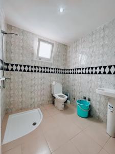 a bathroom with a tub and a toilet and a sink at RÉSIDENCE SNIYA in Dakhla