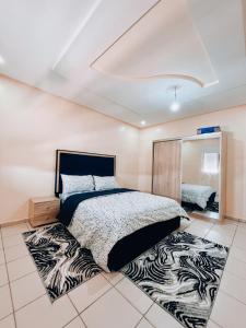 Schlafzimmer mit einem Bett mit einem Zebra-Teppich in der Unterkunft RÉSIDENCE SNIYA in Ad-Dakhla