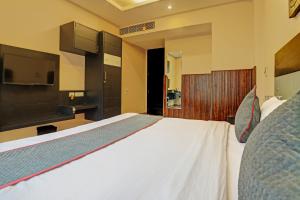 1 dormitorio con 1 cama blanca y TV de pantalla plana en Super Townhouse 1242 Tipsyy Inn 16, en Gurgaon