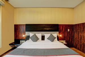 een slaapkamer met een groot bed met een houten hoofdeinde bij Super Townhouse 1242 Tipsyy Inn 16 in Gurgaon