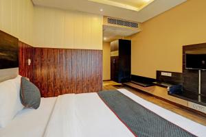 een slaapkamer met een groot bed en een flatscreen-tv bij Super Townhouse 1242 Tipsyy Inn 16 in Gurgaon