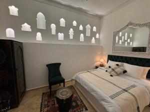 - une chambre avec un lit, un miroir et une chaise dans l'établissement Riad Al-Qurtubi, à Tanger