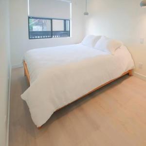 a large white bed in a room with a window at Newly Renovated 2 Bedroom Condo in Japantown! Near Railtown & Gastown! in Vancouver