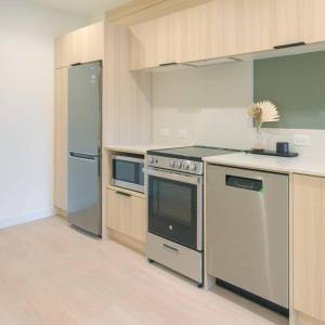 a kitchen with a stove and a refrigerator at Newly Renovated 2 Bedroom Condo in Japantown! Near Railtown & Gastown! in Vancouver