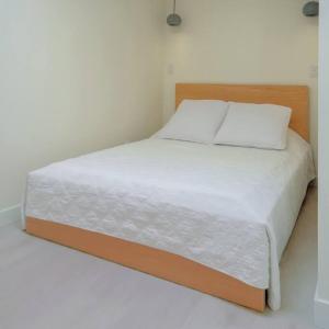 un letto con lenzuola e cuscini bianchi in una camera da letto di Newly Renovated 2 Bedroom Condo in Japantown! Near Railtown & Gastown! a Vancouver