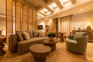 uma sala de estar com um sofá, cadeiras e uma mesa em Cinco Quintas Hotel Boutique By SOHO em Cartagena das Índias