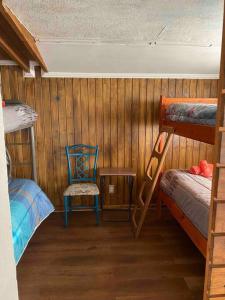 a room with two bunk beds and a chair at Habitación para 4, acogedor, familiar, equipado, baño compartido 