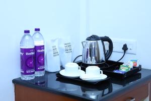 a counter with a tea kettle and two bottles of water at Nakshatra Emerald in Guruvāyūr