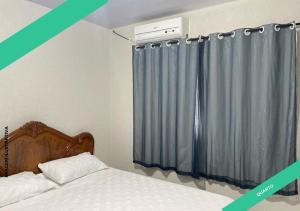 een slaapkamer met een bed en een grijs gordijn bij Apartamento Maravilhoso 2 in Foz do Iguaçu