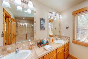 a bathroom with two sinks and a shower at Spruce Chalet in Granby +51 photos