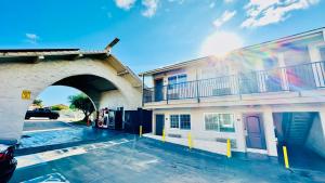 ein Parkplatz neben einem Gebäude mit Brücke in der Unterkunft Rodeway Inn Lemon Grove San Diego East in Lemon Grove