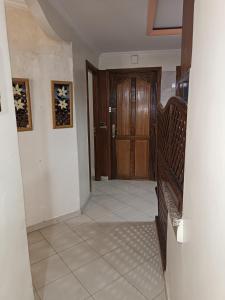 un couloir avec une porte en bois et du carrelage. dans l'établissement Quartier riad résidence riad, à Ifrane