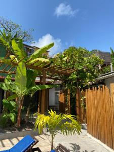 a patio with chairs and a wooden pergola at Pousada Barbara in Pipa