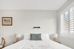 um quarto branco com uma cama e 2 candeeiros em White Dolphin, Unit 7 em Gold Coast