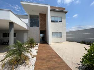 a house with a walkway in front of it at Quartos privativos - Casa de alto padrão in Guaratinguetá