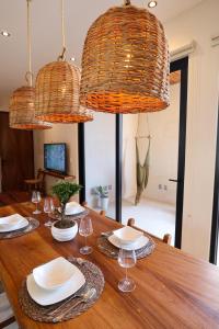 a dining room table with two chandeliers and plates and wine glasses at Akbal Tulum in Tulum