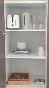 a shelf with plates and other kitchen items on it at Townsville City Motel in Townsville