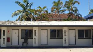 un bâtiment avec des portes blanches et une chaise à l'avant dans l'établissement Townsville City Motel, à Townsville