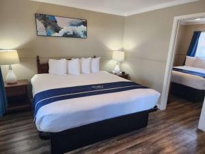 Habitación de hotel con 1 cama grande y 2 lámparas en Omeo Suites Glass Beach, en Fort Bragg