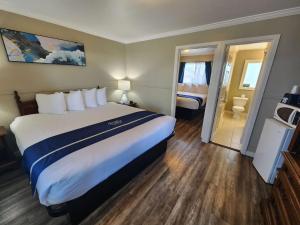 a hotel room with a large bed and a bathroom at Omeo Suites Glass Beach in Fort Bragg